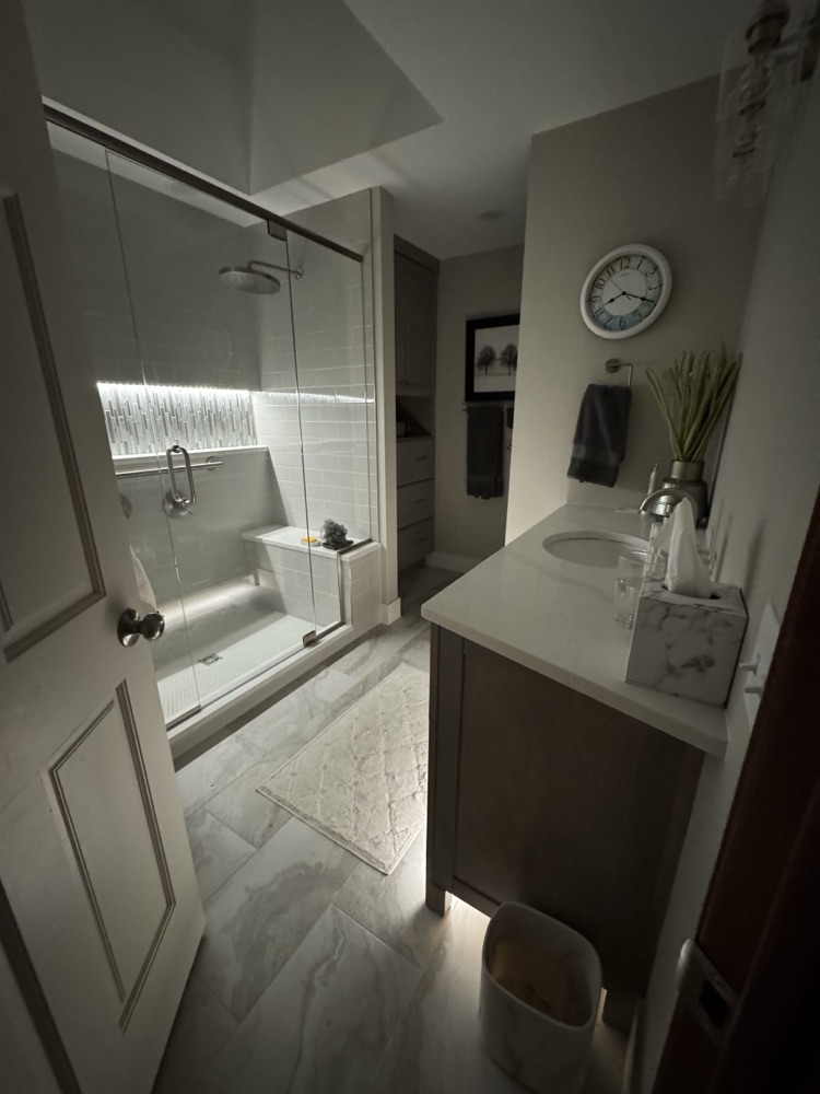 Spa-style bathroom with lit shower niche and glass enclosure