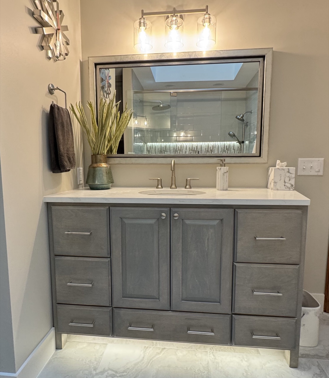 Finished bathroom with gray vanity and glass shower